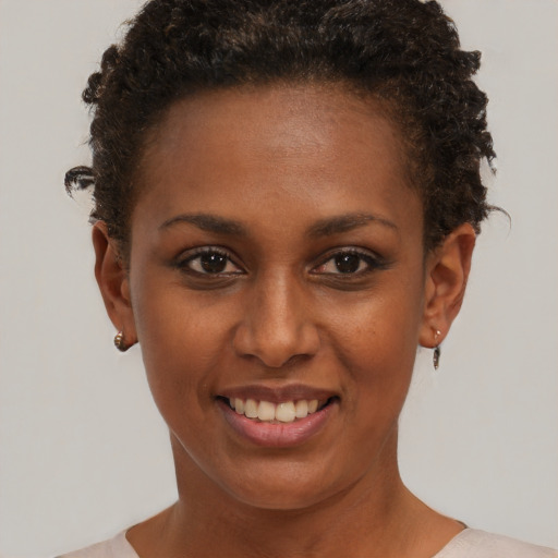 Joyful black young-adult female with short  brown hair and brown eyes