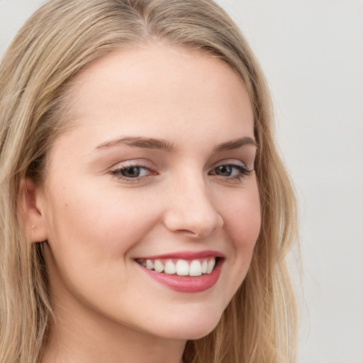 Joyful white young-adult female with long  brown hair and blue eyes