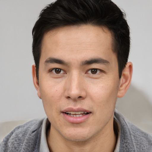 Joyful asian young-adult male with short  brown hair and brown eyes