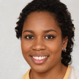 Joyful black young-adult female with long  brown hair and brown eyes