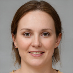 Joyful white young-adult female with medium  brown hair and grey eyes