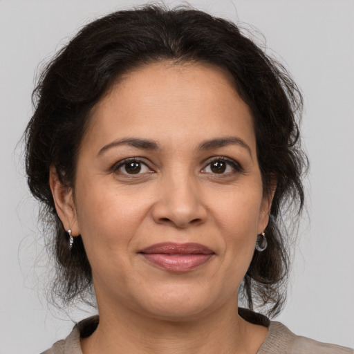 Joyful latino adult female with medium  brown hair and brown eyes