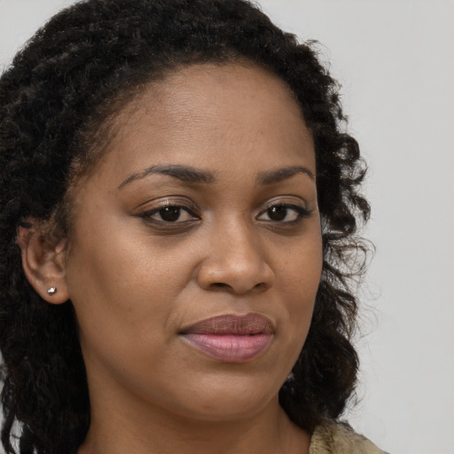 Joyful black young-adult female with long  brown hair and brown eyes