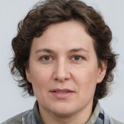 Joyful white adult female with medium  brown hair and grey eyes