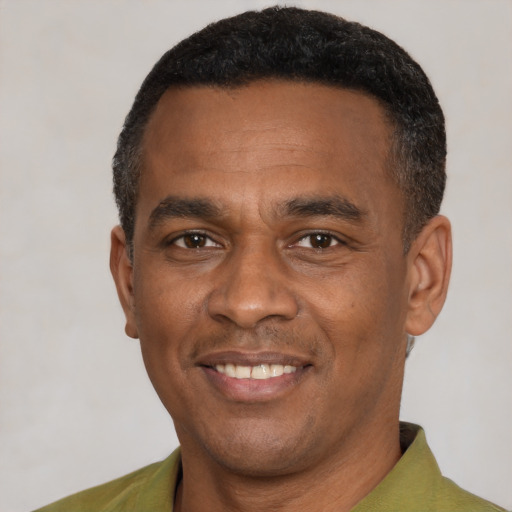 Joyful black adult male with short  black hair and brown eyes
