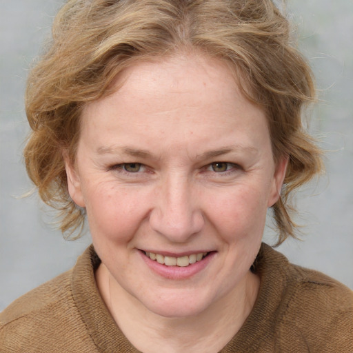 Joyful white adult female with medium  brown hair and blue eyes