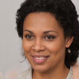 Joyful black adult female with long  brown hair and brown eyes