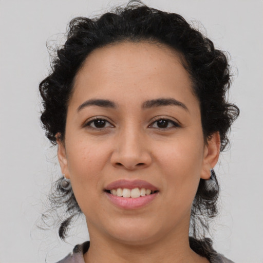 Joyful latino young-adult female with medium  brown hair and brown eyes