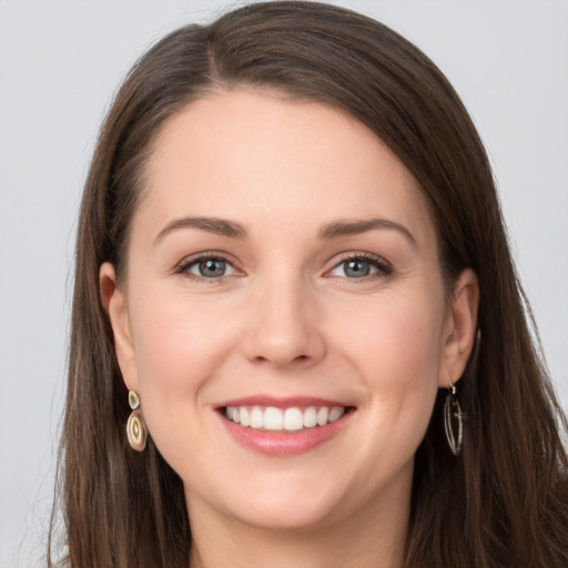 Joyful white young-adult female with long  brown hair and grey eyes