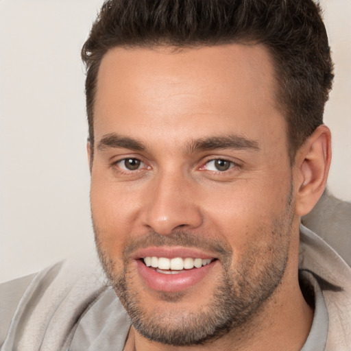 Joyful white young-adult male with short  brown hair and brown eyes