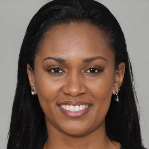 Joyful black young-adult female with long  black hair and brown eyes
