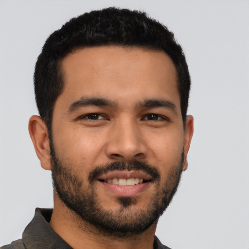 Joyful latino young-adult male with short  black hair and brown eyes