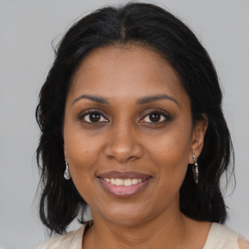 Joyful black young-adult female with medium  brown hair and brown eyes