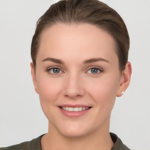 Joyful white young-adult female with short  brown hair and grey eyes