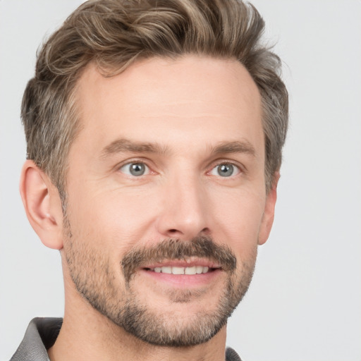 Joyful white adult male with short  brown hair and grey eyes