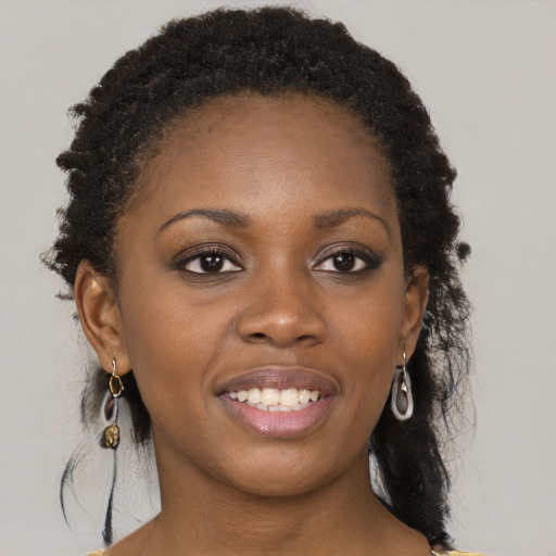 Joyful black young-adult female with long  brown hair and brown eyes
