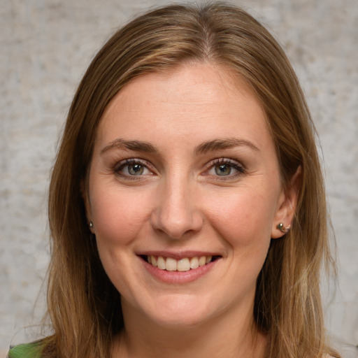 Joyful white young-adult female with long  brown hair and green eyes