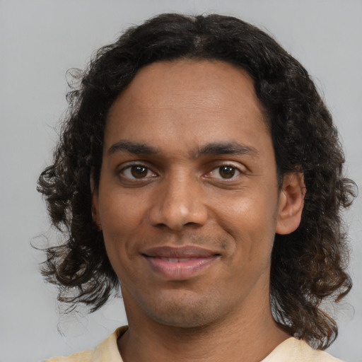 Joyful black adult male with medium  brown hair and brown eyes