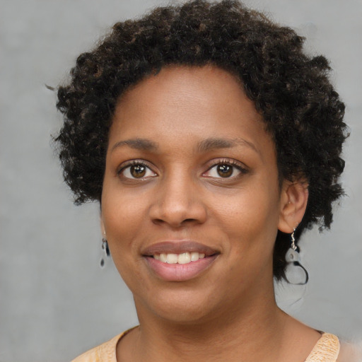 Joyful black young-adult female with short  brown hair and brown eyes