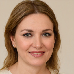 Joyful white young-adult female with medium  brown hair and green eyes