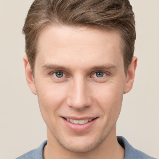 Joyful white young-adult male with short  brown hair and grey eyes