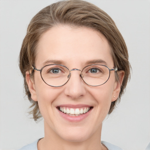 Joyful white adult female with medium  brown hair and blue eyes