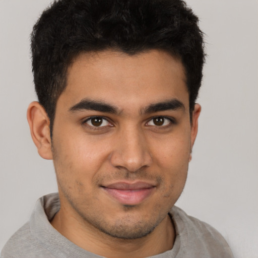 Joyful latino young-adult male with short  brown hair and brown eyes