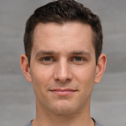 Joyful white young-adult male with short  brown hair and grey eyes