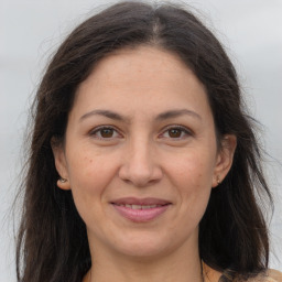 Joyful white adult female with long  brown hair and brown eyes