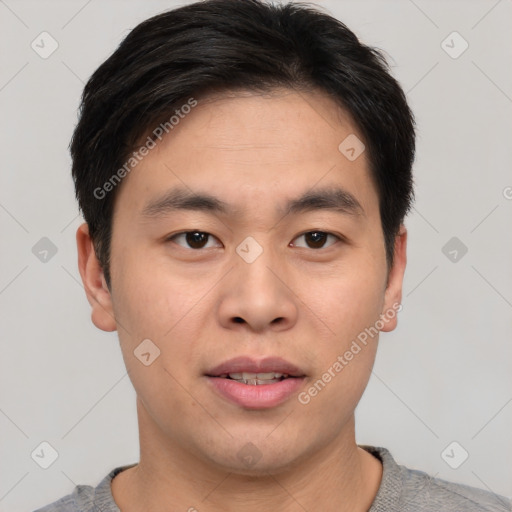 Joyful asian young-adult male with short  brown hair and brown eyes