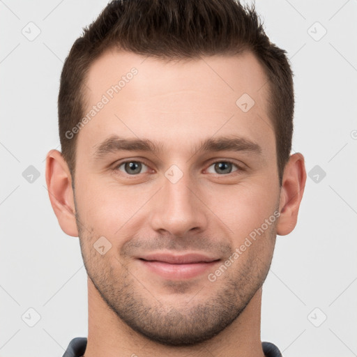 Joyful white young-adult male with short  brown hair and grey eyes