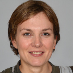 Joyful white adult female with medium  brown hair and grey eyes