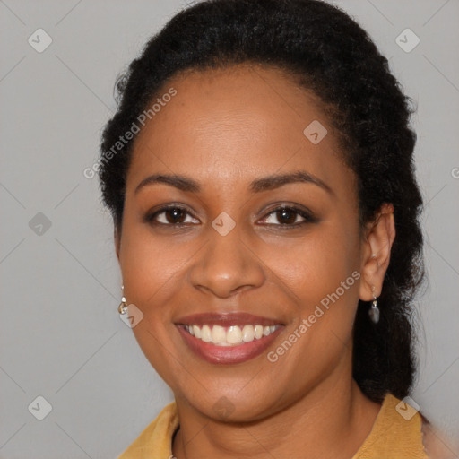 Joyful black young-adult female with long  brown hair and brown eyes