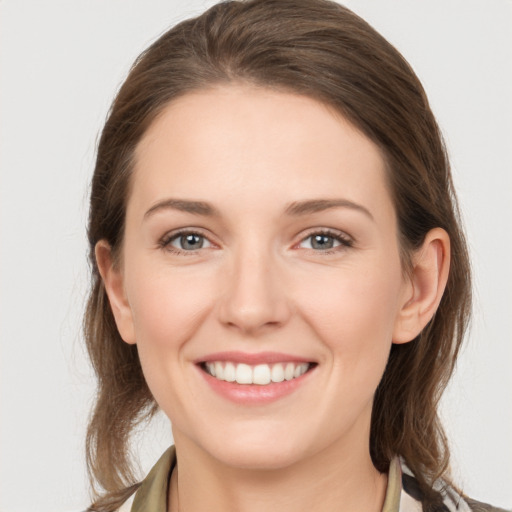 Joyful white young-adult female with medium  brown hair and grey eyes