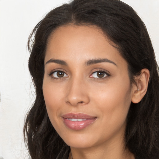 Joyful latino young-adult female with long  brown hair and brown eyes