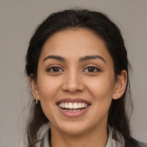 Joyful latino young-adult female with long  brown hair and brown eyes