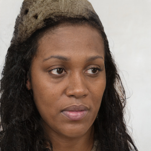 Joyful black young-adult female with long  brown hair and brown eyes