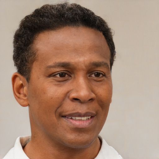Joyful latino young-adult male with short  brown hair and brown eyes