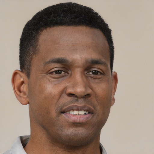 Joyful black young-adult male with short  brown hair and brown eyes