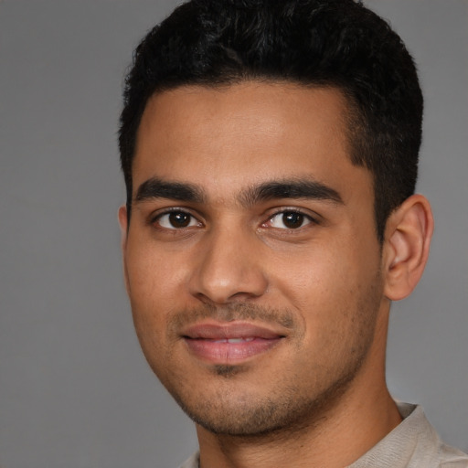 Joyful latino young-adult male with short  black hair and brown eyes