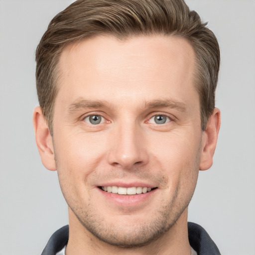 Joyful white young-adult male with short  brown hair and grey eyes