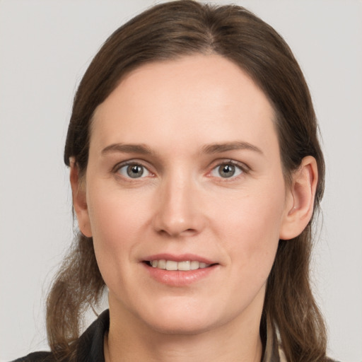 Joyful white young-adult female with medium  brown hair and grey eyes