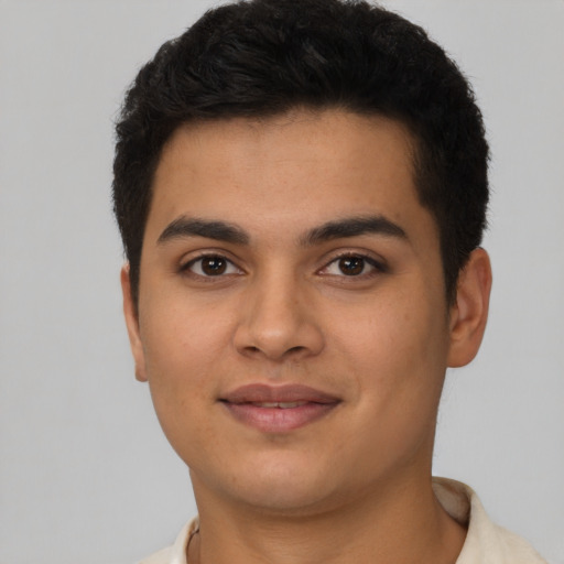 Joyful latino young-adult male with short  brown hair and brown eyes