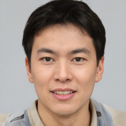 Joyful asian young-adult male with short  brown hair and brown eyes