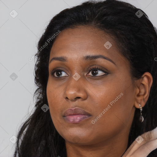 Joyful black young-adult female with long  black hair and brown eyes