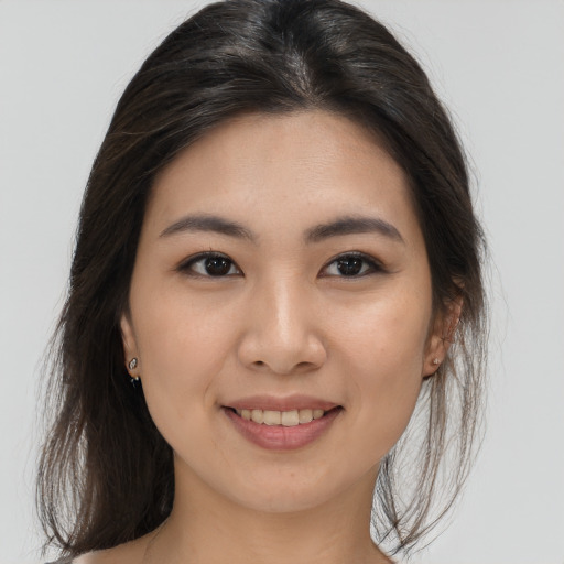 Joyful asian young-adult female with long  brown hair and brown eyes