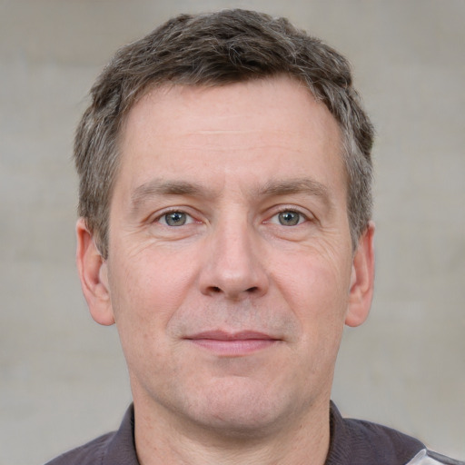 Joyful white adult male with short  brown hair and grey eyes