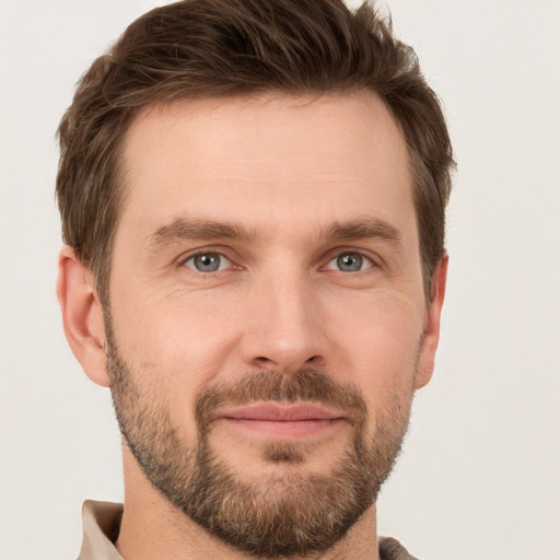 Joyful white young-adult male with short  brown hair and grey eyes