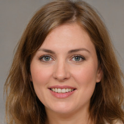 Joyful white young-adult female with long  brown hair and green eyes