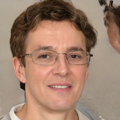 Joyful white adult male with short  brown hair and blue eyes